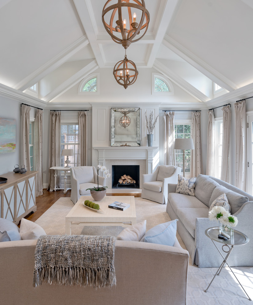 Design ideas for a large transitional open concept living room in DC Metro with medium hardwood floors, a standard fireplace, a stone fireplace surround, a concealed tv, brown floor and grey walls.