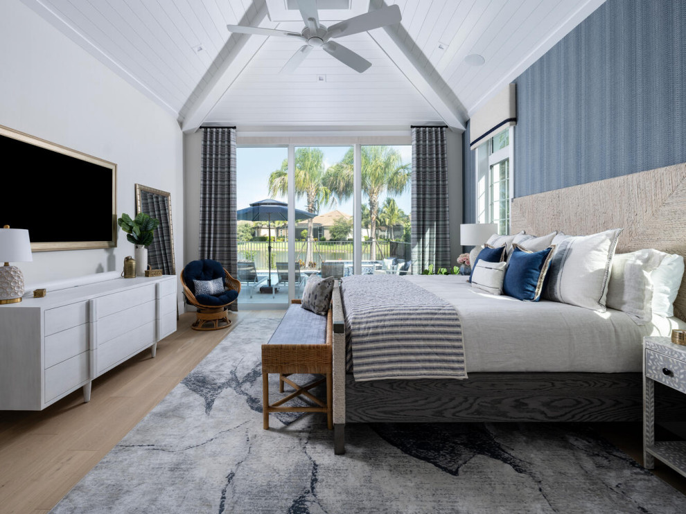 Large beach style master bedroom in Miami with wallpaper.