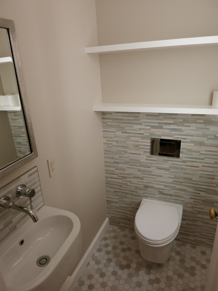 This is an example of a small contemporary powder room in San Francisco with a wall-mount toilet, multi-coloured tile, porcelain tile, beige walls, porcelain floors and a wall-mount sink.