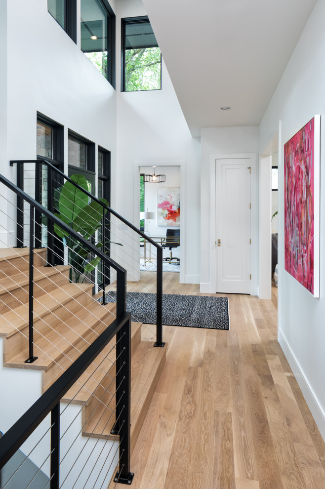 Large contemporary foyer in Minneapolis with white walls, light hardwood floors, a single front door, a black front door and brown floor.