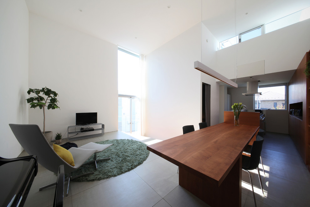 This is an example of a contemporary open concept living room in Tokyo Suburbs with white walls, ceramic floors, no fireplace, a freestanding tv and grey floor.