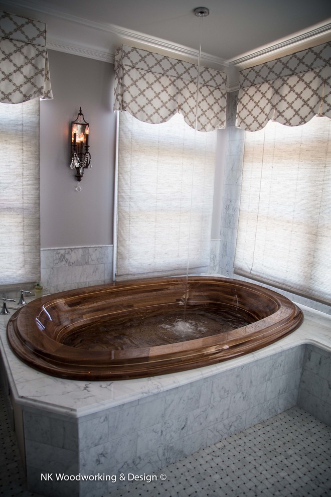 Example of a transitional drop-in bathtub design in Seattle with marble countertops