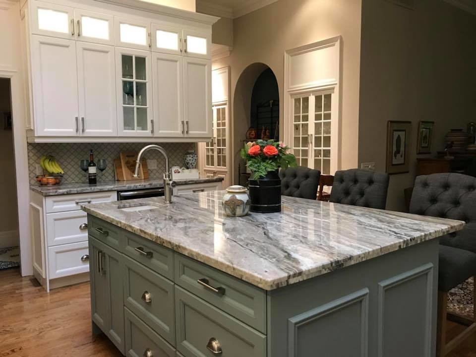 This is an example of a large transitional l-shaped kitchen pantry in Toronto with a farmhouse sink, recessed-panel cabinets, white cabinets, granite benchtops, white splashback, porcelain splashback, stainless steel appliances, medium hardwood floors, with island and blue benchtop.
