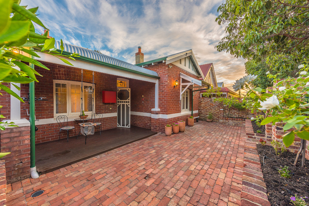 Traditional backyard patio in Perth with brick pavers and a roof extension.
