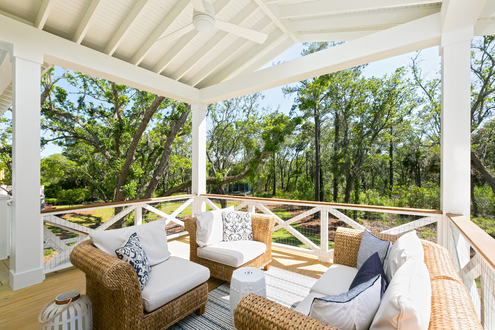 Photo of a beach style backyard deck in Charleston with a roof extension.