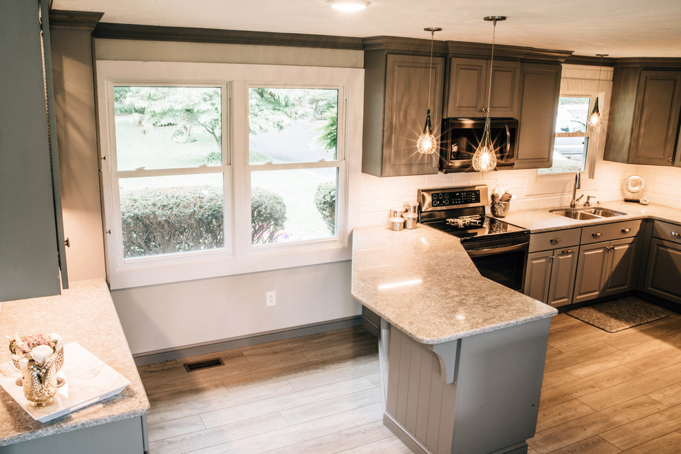 Example of a mid-sized transitional u-shaped medium tone wood floor and brown floor eat-in kitchen design with a double-bowl sink, raised-panel cabinets, gray cabinets, granite countertops, white backsplash, ceramic backsplash, stainless steel appliances, a peninsula and gray countertops