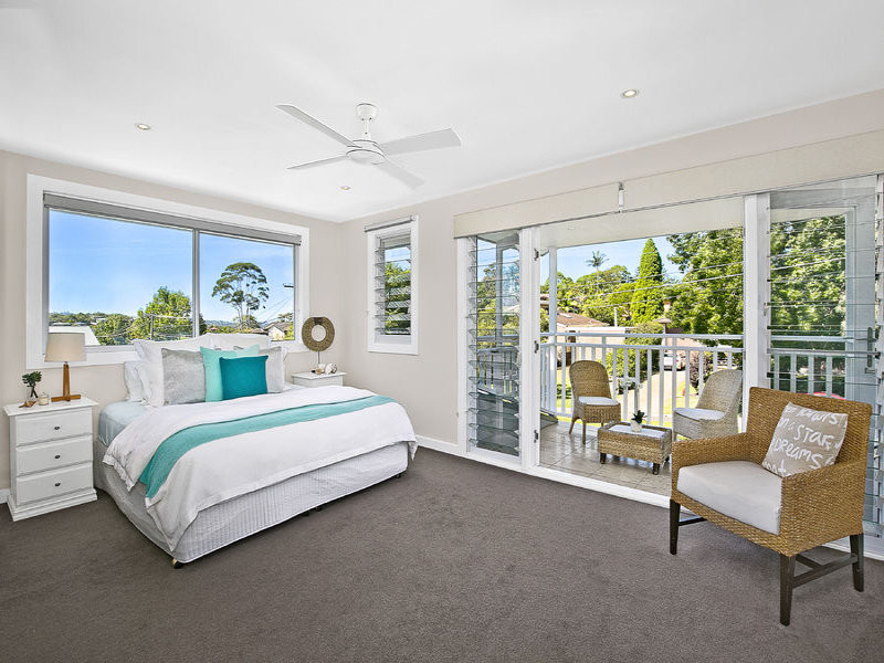 Design ideas for a mid-sized beach style master bedroom in Sydney with white walls and carpet.