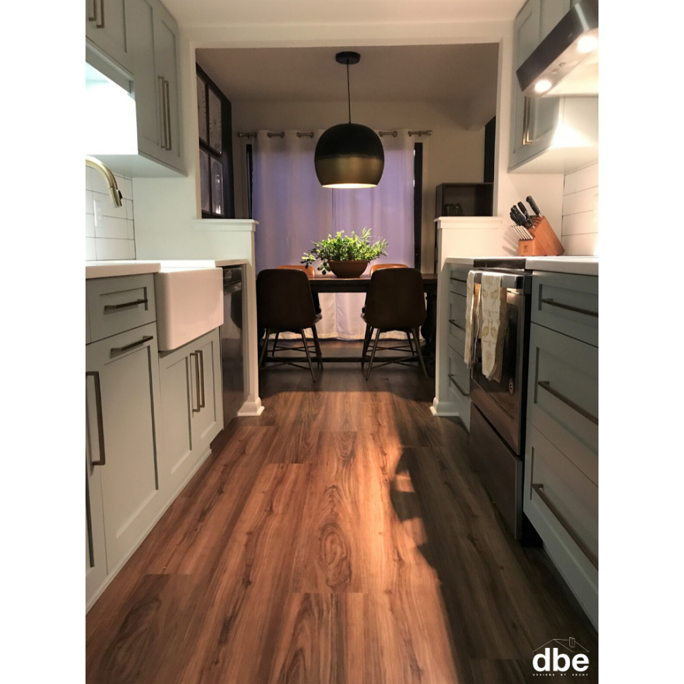 Kitchen - small transitional galley vinyl floor and brown floor kitchen idea with a farmhouse sink, shaker cabinets, blue cabinets, quartz countertops, white backsplash, subway tile backsplash, stainless steel appliances, no island and white countertops