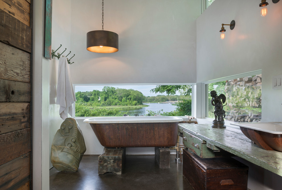 This is an example of an asian master bathroom in Providence with a freestanding tub, white walls, concrete floors, a vessel sink and wood benchtops.