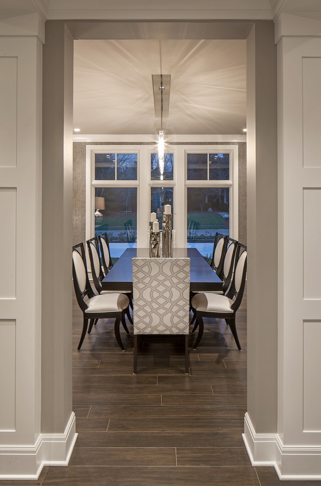 This is an example of a large transitional separate dining room in Omaha with metallic walls and ceramic floors.