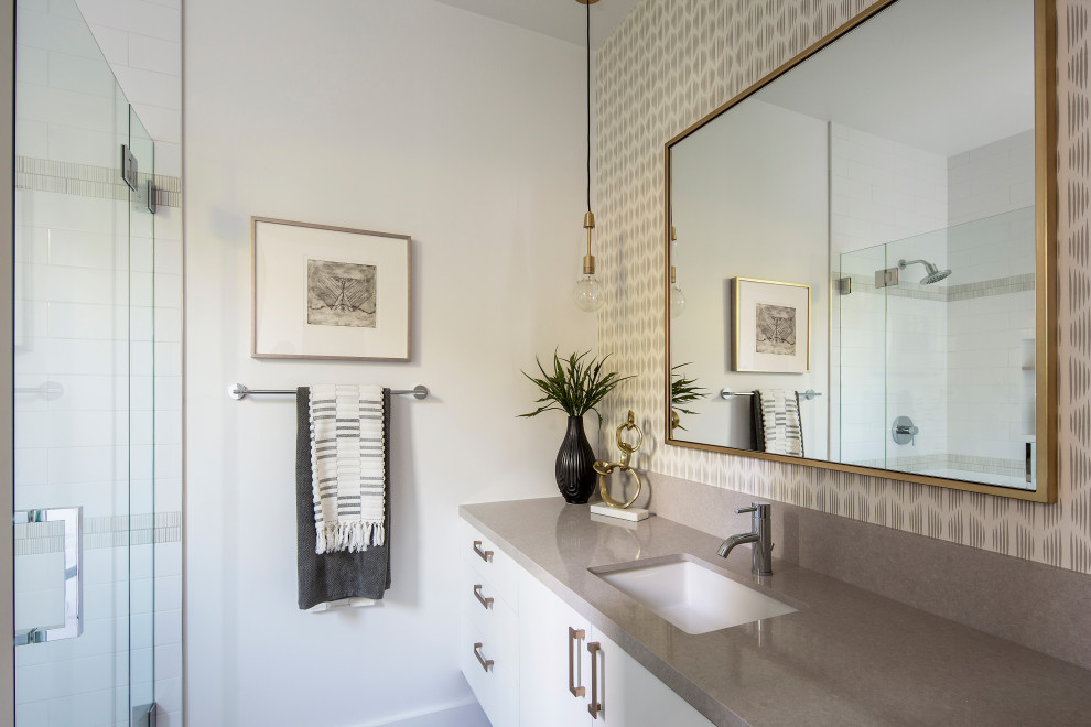 Mid-sized contemporary kids bathroom in Orange County with flat-panel cabinets, white cabinets, a curbless shower, white walls, engineered quartz benchtops, a hinged shower door, grey benchtops, a single vanity, a built-in vanity and wallpaper.