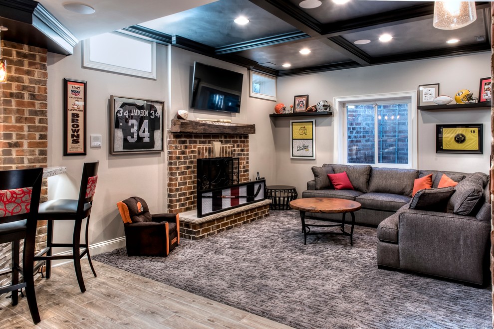 This is an example of a large country look-out basement in Chicago with grey walls, porcelain floors, a standard fireplace and a brick fireplace surround.