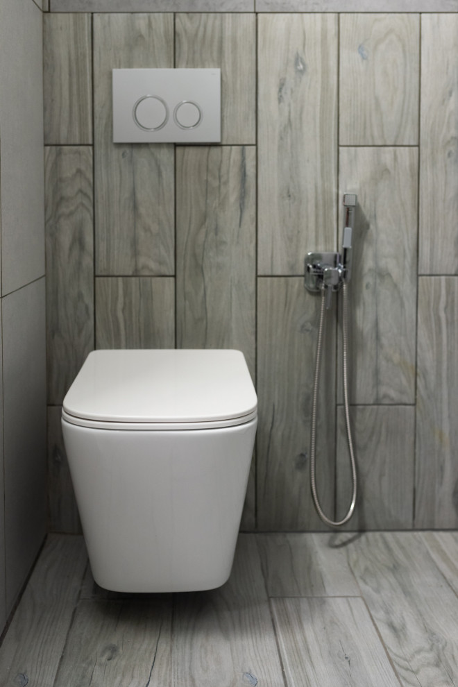Inspiration för ett litet funkis vit vitt badrum med dusch, med släta luckor, grå skåp, en dusch i en alkov, en vägghängd toalettstol, grå kakel, porslinskakel, ett integrerad handfat, grått golv och med dusch som är öppen