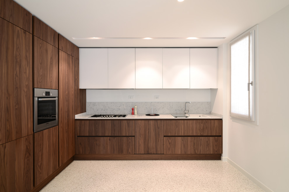 Photo of a large modern l-shaped separate kitchen in Venice with flat-panel cabinets, medium wood cabinets, grey splashback, stone slab splashback and stainless steel appliances.