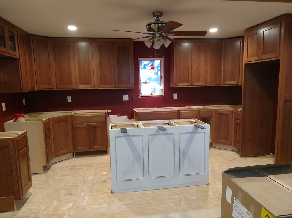 Inspiration for a large transitional u-shaped kitchen remodel with recessed-panel cabinets, medium tone wood cabinets, granite countertops, multicolored backsplash, an island and multicolored countertops
