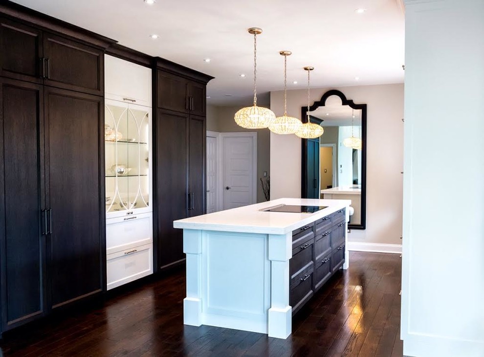Mid-sized transitional single-wall dark wood floor and brown floor enclosed kitchen photo with a farmhouse sink, shaker cabinets, white cabinets, white backsplash, stainless steel appliances, an island, quartz countertops and white countertops
