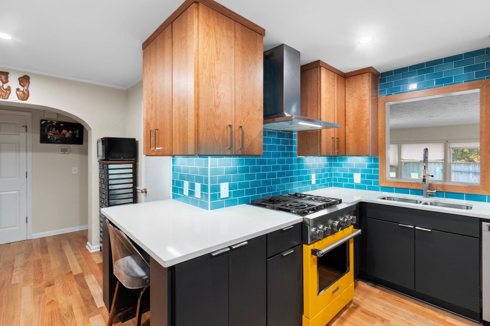 Photo of an eclectic kitchen in Other with flat-panel cabinets, brown cabinets, blue splashback, subway tile splashback, stainless steel appliances, light hardwood floors, brown floor and white benchtop.