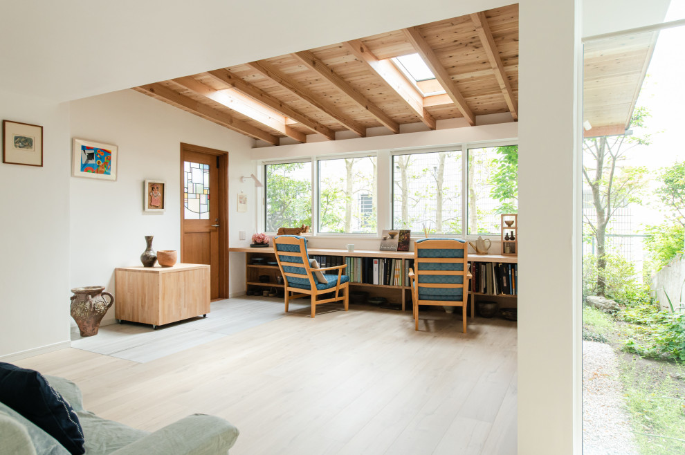 Ejemplo de galería contemporánea pequeña sin chimenea con suelo de contrachapado, techo con claraboya y suelo beige