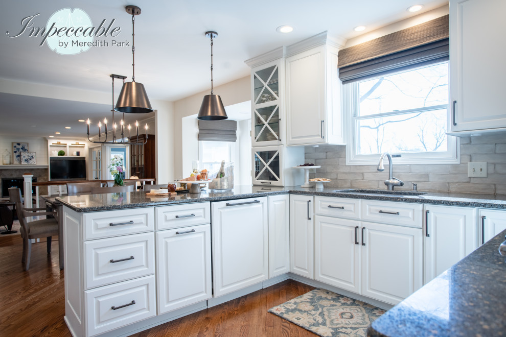 Large transitional u-shaped medium tone wood floor and brown floor eat-in kitchen photo in Chicago with an undermount sink, raised-panel cabinets, white cabinets, quartz countertops, beige backsplash, subway tile backsplash, paneled appliances, a peninsula and multicolored countertops