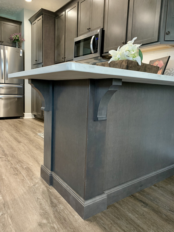 Example of a large transitional u-shaped vinyl floor and gray floor open concept kitchen design with an undermount sink, shaker cabinets, gray cabinets, quartz countertops, gray backsplash, ceramic backsplash, stainless steel appliances, a peninsula and white countertops