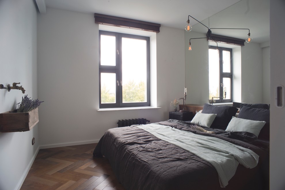Photo of a small industrial master bedroom in Moscow with green walls, medium hardwood floors and brown floor.