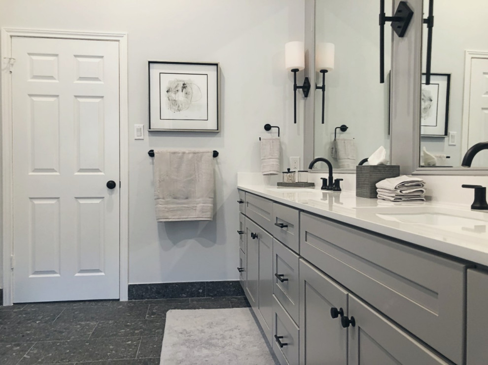 This is an example of a large contemporary master wet room bathroom in Houston with shaker cabinets, grey cabinets, a drop-in tub, a two-piece toilet, grey walls, ceramic floors, an undermount sink, engineered quartz benchtops, black floor, a hinged shower door, white benchtops, a niche, a double vanity, a built-in vanity and decorative wall panelling.