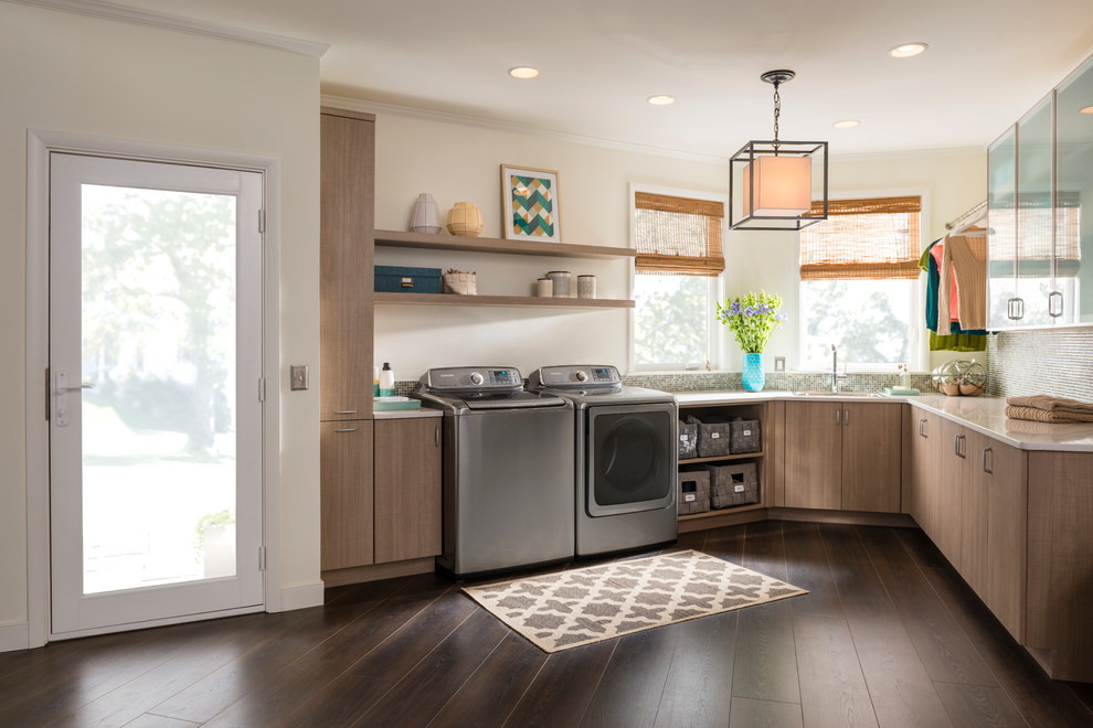 Design ideas for a mid-sized transitional u-shaped utility room in New York with a drop-in sink, flat-panel cabinets, medium wood cabinets, solid surface benchtops, beige walls, dark hardwood floors and a side-by-side washer and dryer.