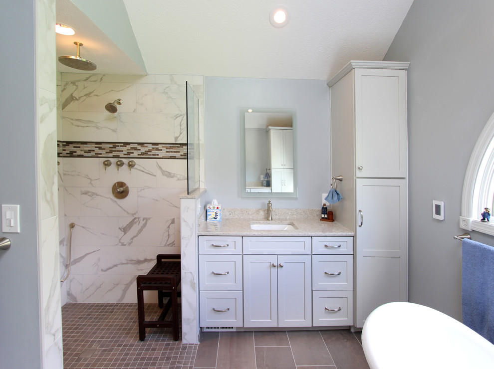 This is an example of a mid-sized master bathroom in Cleveland with flat-panel cabinets, grey cabinets, a freestanding tub, a curbless shower, a two-piece toilet, black and white tile, ceramic tile, blue walls, ceramic floors, an undermount sink, engineered quartz benchtops, beige floor, an open shower and beige benchtops.