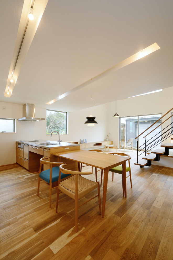 Inspiration pour une salle à manger ouverte sur le salon minimaliste avec un mur blanc, un sol en bois brun, un plafond en papier peint et du papier peint.