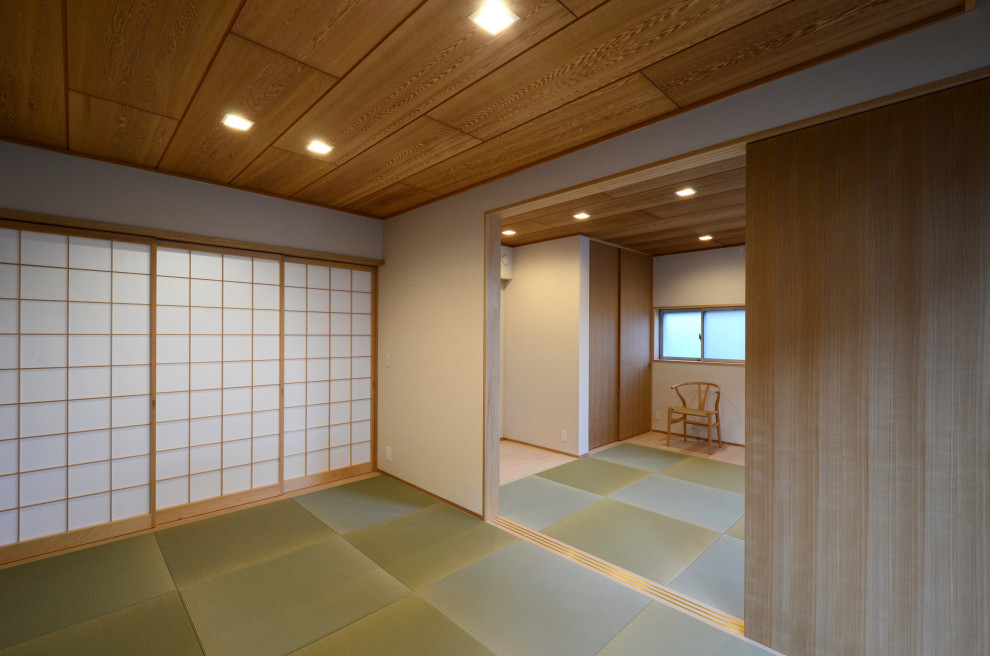 Esempio di un soggiorno etnico di medie dimensioni e aperto con pareti bianche, pavimento in tatami, TV autoportante, soffitto in legno e carta da parati