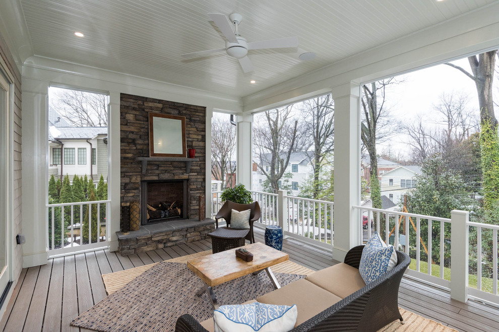 This is an example of a mid-sized arts and crafts backyard deck in DC Metro with with fireplace and a roof extension.