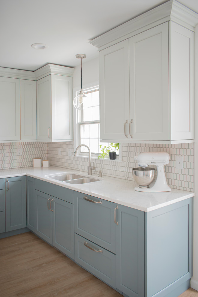 Inspiration for a mid-sized transitional l-shaped light wood floor and beige floor eat-in kitchen remodel in Chicago with an undermount sink, shaker cabinets, quartz countertops, white backsplash, mosaic tile backsplash, stainless steel appliances, no island, white countertops and blue cabinets