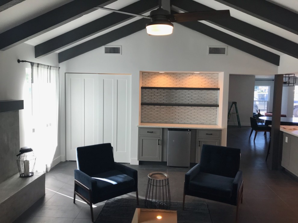 Photo of a mid-sized midcentury formal open concept living room in Tampa with white walls, porcelain floors, a standard fireplace, a concrete fireplace surround, no tv and grey floor.