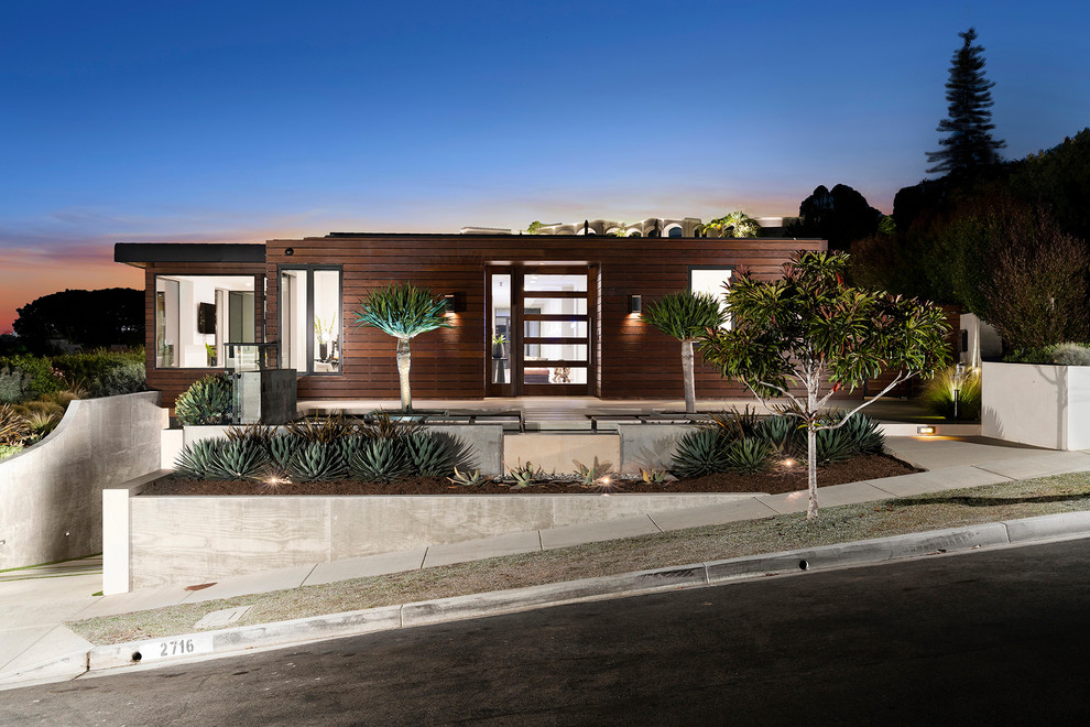Photo of a contemporary two-storey brown house exterior in Orange County with wood siding and a flat roof.