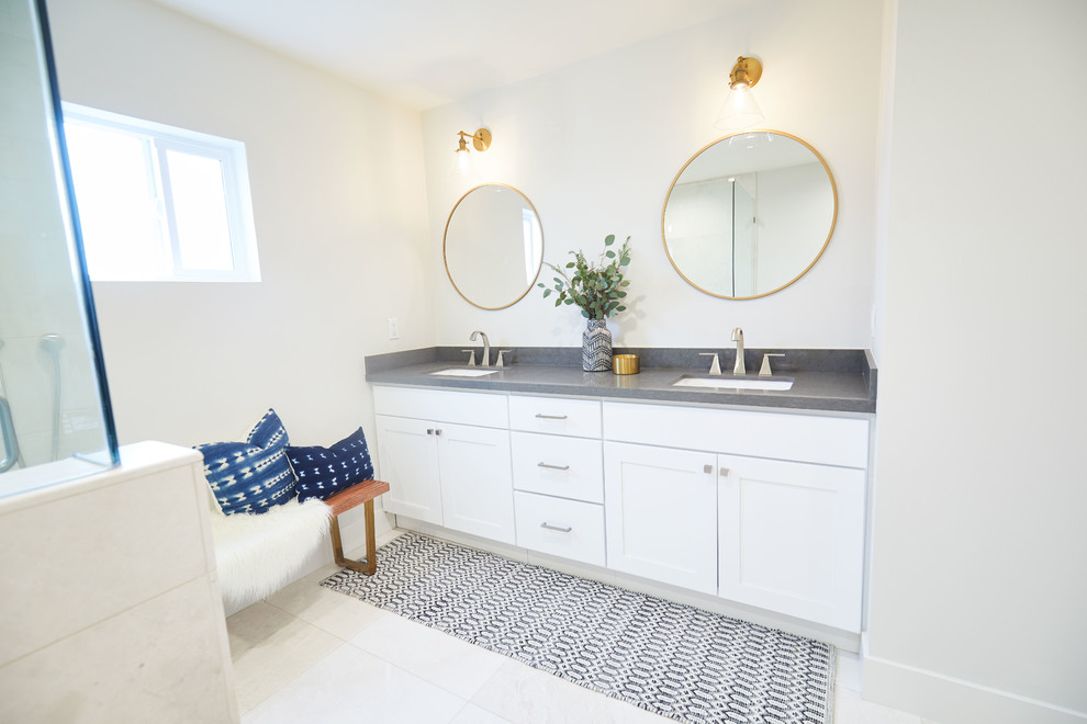 Photo of a mid-sized transitional master bathroom in San Diego with shaker cabinets, white cabinets, a drop-in tub, a corner shower, a two-piece toilet, white walls, an undermount sink, quartzite benchtops, white floor and a hinged shower door.