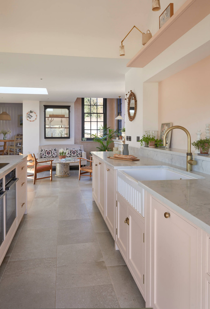 Inspiration för stora lantliga linjära grått kök med öppen planlösning, med en rustik diskho, skåp i shakerstil, bänkskiva i kvartsit, rosa stänkskydd, svarta vitvaror, klinkergolv i keramik, en köksö och flerfärgat golv
