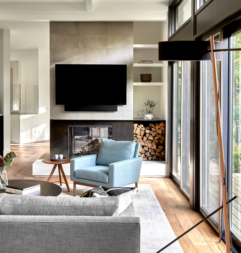 Large contemporary open concept family room in Chicago with white walls, light hardwood floors, a two-sided fireplace, a tile fireplace surround and a wall-mounted tv.