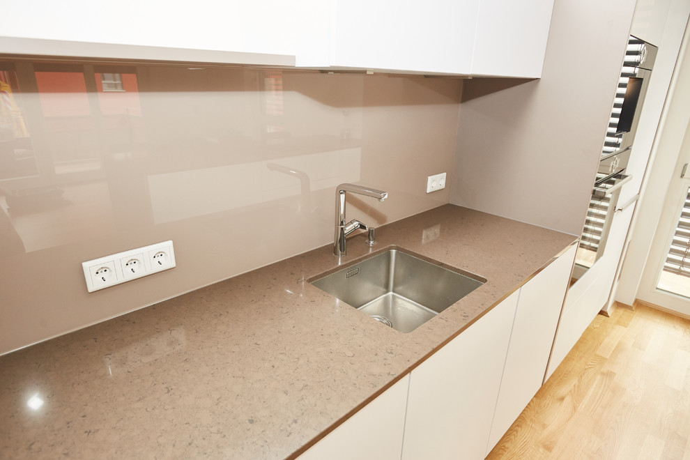 Offene, Zweizeilige, Große Moderne Küche mit Einbauwaschbecken, weißen Schränken, Quarzwerkstein-Arbeitsplatte, Küchenrückwand in Braun, Glasrückwand, bunten Elektrogeräten, Kücheninsel und brauner Arbeitsplatte in München