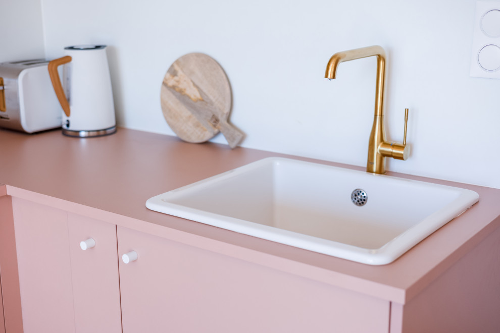 Scandinavian l-shaped open plan kitchen in Other with an undermount sink, flat-panel cabinets, pink cabinets, laminate benchtops, light hardwood floors and pink benchtop.