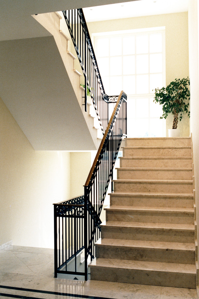 Large traditional marble straight staircase in Dusseldorf with marble risers and metal railing.