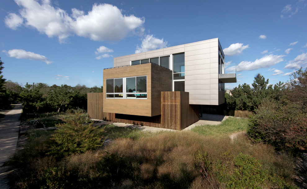 Beach style exterior in New York with wood siding and a flat roof.