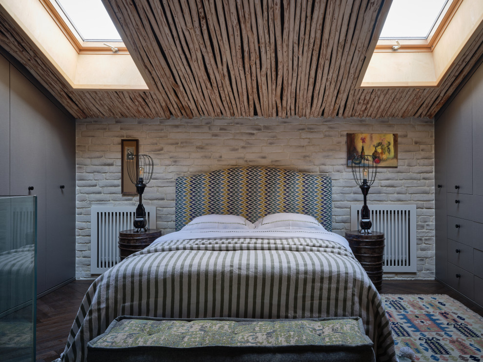Modelo de dormitorio principal, abovedado y blanco y madera urbano de tamaño medio con paredes beige, suelo de madera oscura, madera, ladrillo y suelo marrón