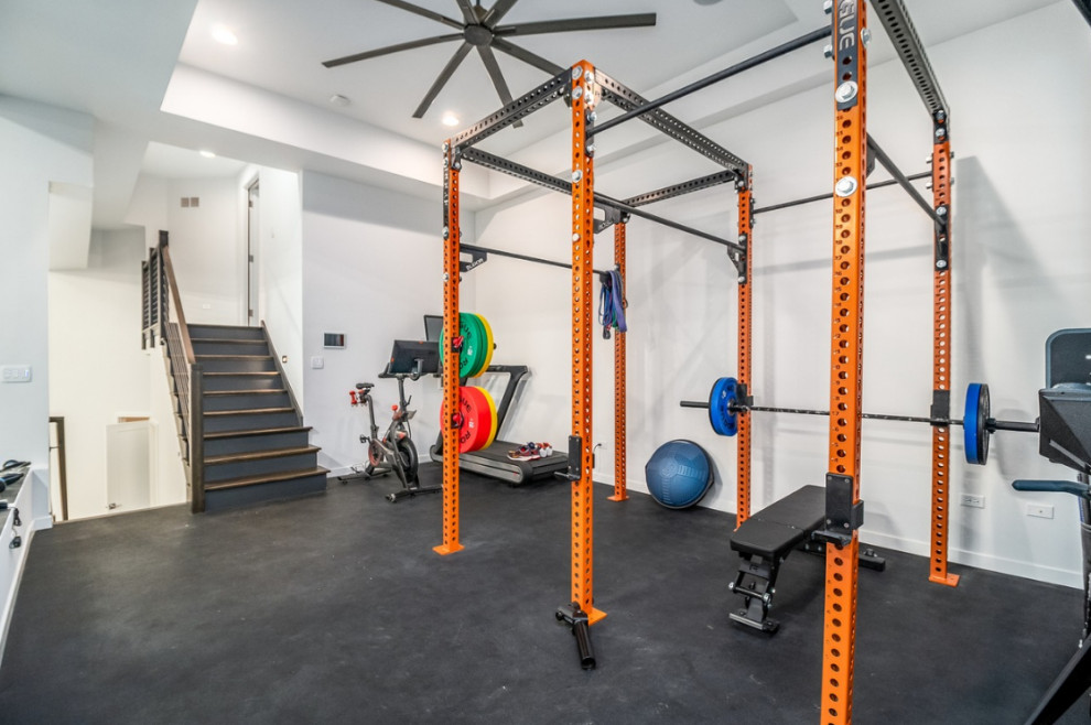 Large modern multipurpose gym in Chicago with white walls, vinyl floors, black floor and coffered.
