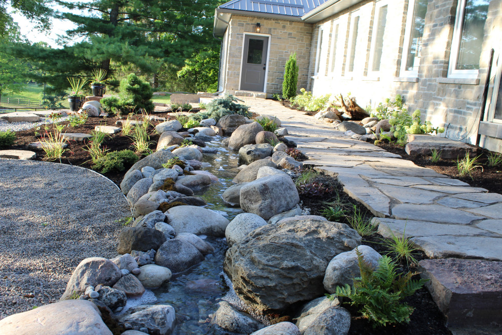 Foto di un giardino american style di medie dimensioni e in cortile con una cascata e pavimentazioni in pietra naturale