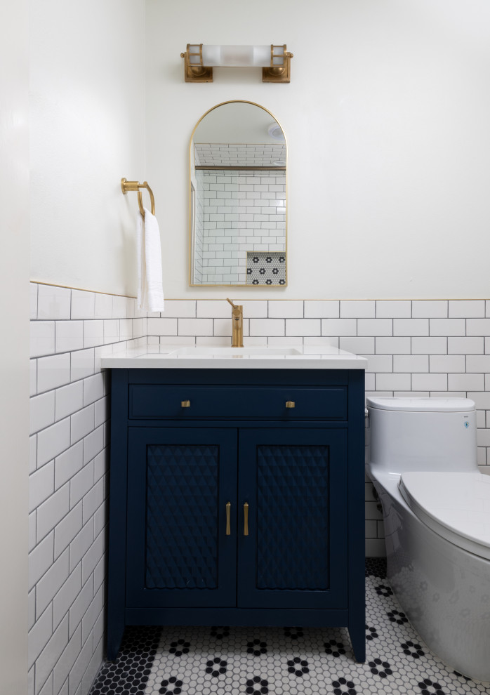 Foto på ett litet eklektiskt vit toalett, med möbel-liknande, blå skåp, en toalettstol med hel cisternkåpa, vit kakel, keramikplattor, vita väggar, mosaikgolv, ett undermonterad handfat, bänkskiva i kvarts och flerfärgat golv