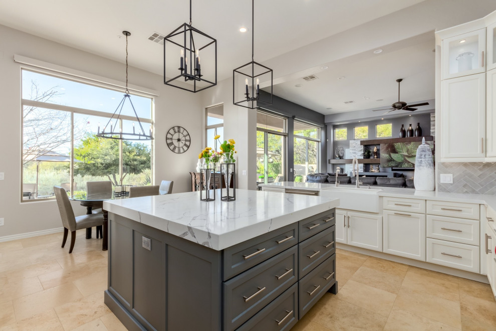 Inspiration for a large transitional u-shaped travertine floor and beige floor eat-in kitchen remodel in Phoenix with a farmhouse sink, shaker cabinets, white cabinets, quartz countertops, gray backsplash, ceramic backsplash, stainless steel appliances, an island and white countertops