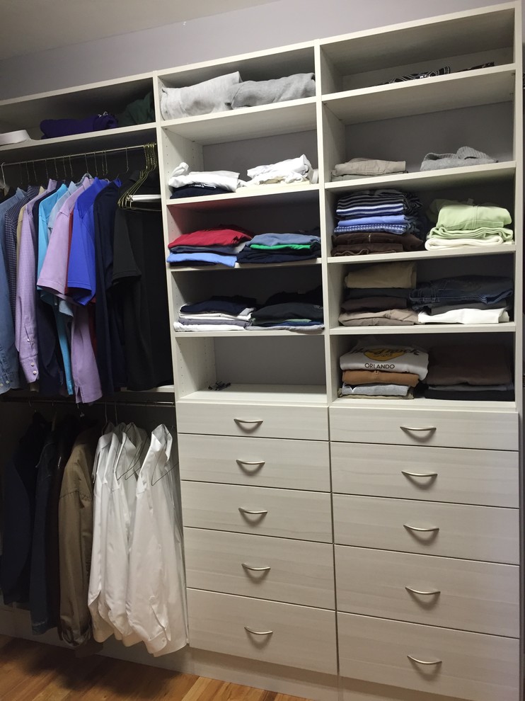 This is an example of a mid-sized modern men's walk-in wardrobe in Miami with open cabinets, white cabinets and light hardwood floors.