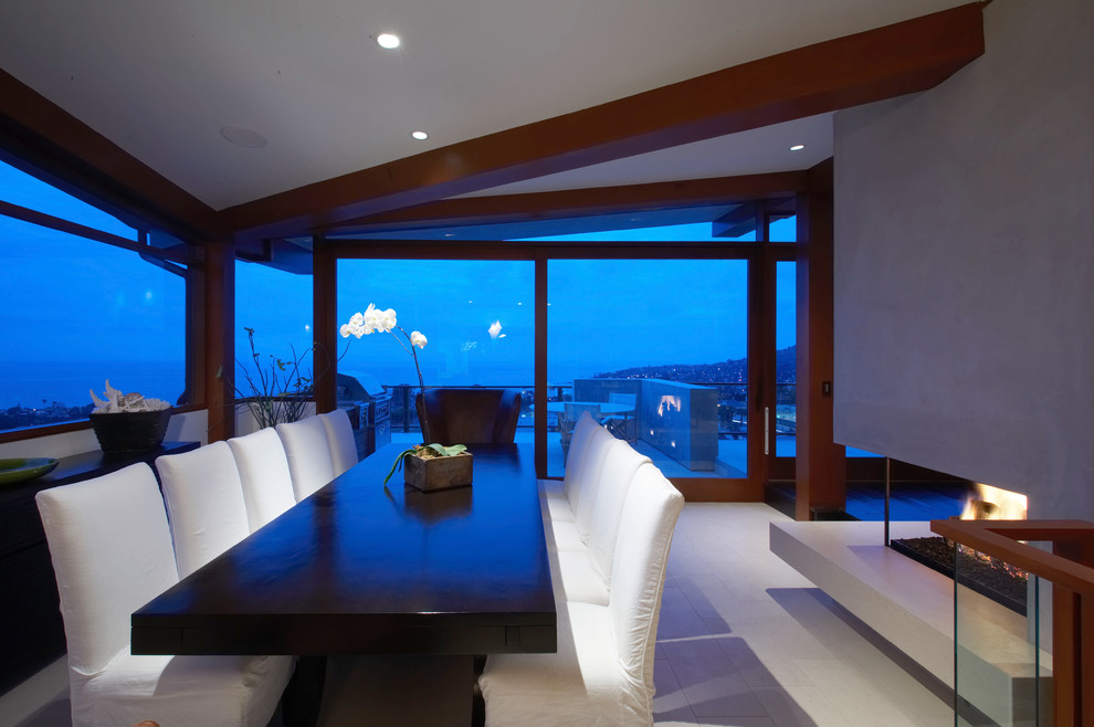 This is an example of a contemporary dining room in Orange County with a two-sided fireplace.