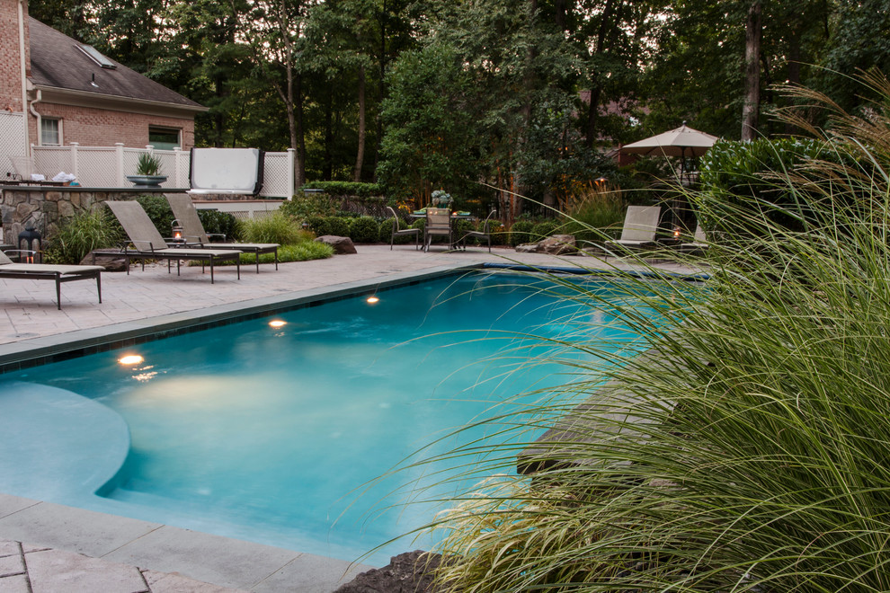 Photo of a mid-sized eclectic backyard rectangular lap pool in DC Metro with a hot tub and concrete pavers.