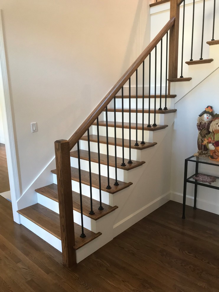 This is an example of a large midcentury wood l-shaped staircase in Portland with painted wood risers and wood railing.